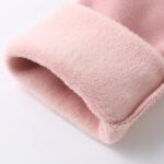 Close-up of pale pink girls winter leggings showing the thick soft fleece lining at the cuff