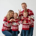 Family wearing matching red reindeer Christmas jumpers during the festive season